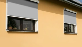 Außenrollos an Hausfassade, effektiver Sonnenschutz und Hitzeschutz für Fenster im Sommer